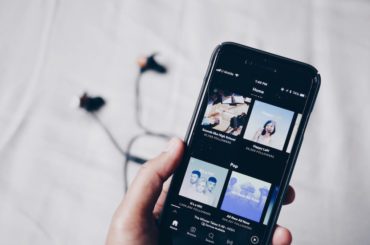 iPhone med musikk app og hodetelefoner